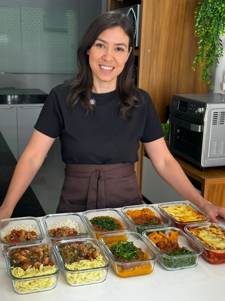 Lindeise na cozinha com as marmitas prontas de uma leva de preparo